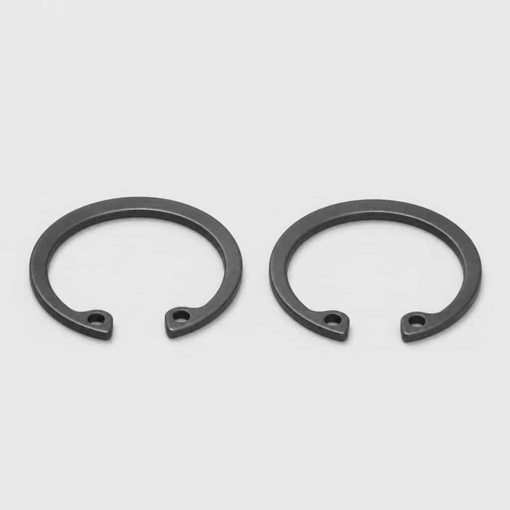 Circlips de piston présenté sur fond clair